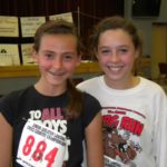 Two young girls at a volunteer event smiling