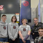 A group of students wearing protective eyewear and wearing T-shirts that say Red Thunder Robotics.