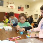 A row of students playing with Legos.