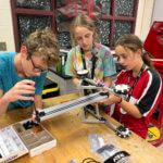 Three young students working on an engineering project.