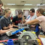 A group of young students working on an engineering and robotics project.
