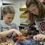 Two members of Red Thunder Robotics working on a project.