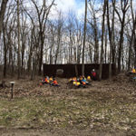 Group of students in the background of an image of the woods.