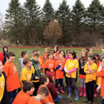 A large group of young students standing in a field.